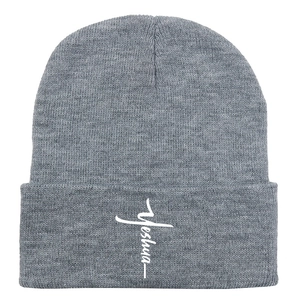 Detail of grey knitted beanie with white Yeshua cross embroidery on the fold-up cuff