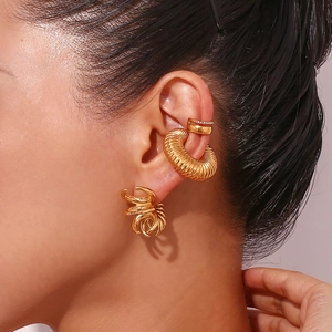 Gros plan d'un ensemble de bagues d'oreille dorées avec nœud torsadé et micro zircons