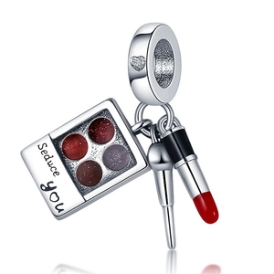 Detail of silver makeup charms with eyeshadow palette, lipstick and brush pendants