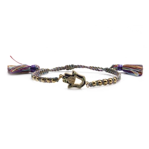 Detail of colorful braided Hamsa bracelet with gold beads and sparkling Fatima hand charm