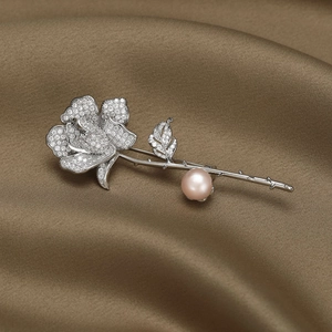 Élégante broche rose avec zircons micro-pave et perle lavande sur fond de satin