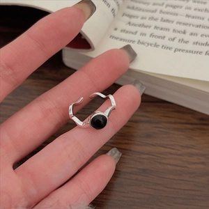 Detail view of wavy 925 sterling silver ring featuring a round black agate stone