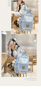 Detail of light blue school backpack with cute bear patch and white rabbit keychain