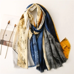 Close-up of lightweight scarf with abstract art patterns and delicate fringe details