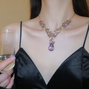 Detail of luxury teardrop purple crystal pendant necklace with gold branch design