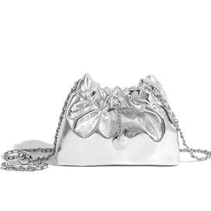 Silver pleated cloud bag with metallic finish and delicate chain strap on white background