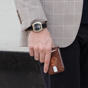 Men's brown checkered RFID blocking slim wallet held by a businessman in a suit