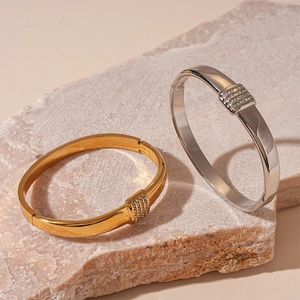Polished gold and silver geometric bangles featuring crystal-encrusted rectangular inserts