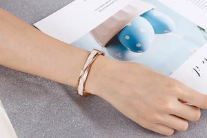 Detail of rose gold double-layer cross bracelet with sparkling crystals on wrist