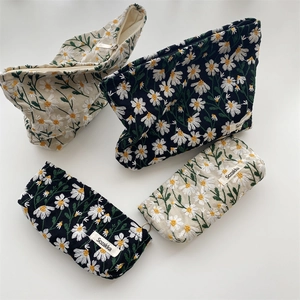 Floral daisy embroidered canvas makeup pouches in black and cream with metal zippers