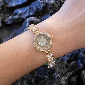Elegant gold women watch with diamond bezel and floral rhinestone bracelet on wrist