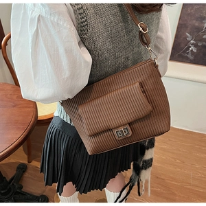 Détail d'un sac bandoulière marron plissé avec fermoir doré et bandoulière réglable