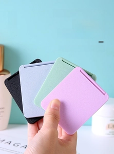Close-up of portable folding makeup mirrors in four colors with matte finish