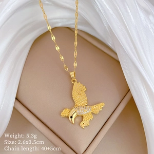 Detail of gold eagle pendant with crystals and dimensions 2.6x3.5cm on white satin