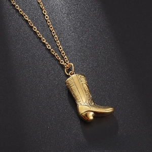 Close-up of gold cowboy boot pendant necklace featuring vintage floral engravings