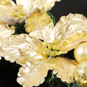 Golden Christmas wreath with metallic flower and shiny ornaments on black background