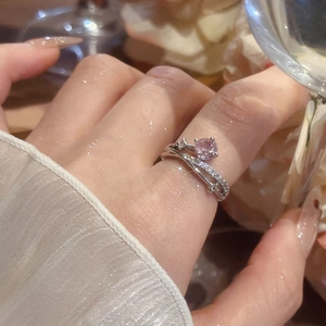 Close-up of a double-layered silver ring with a round pink gemstone and pavé accents