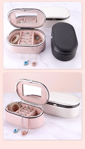 Detail of portable oval jewelry box with built-in mirror and ring storage slots
