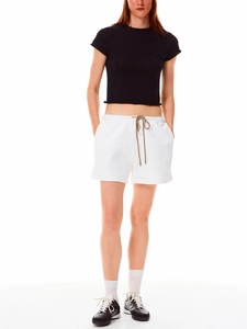 Full body shot of a sporty black crop top and white drawstring shorts set with sneakers