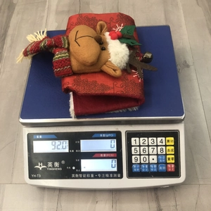 Detail of Christmas stocking with plush reindeer motif showing weight of 92g on a scale