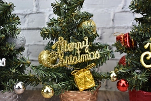 Three mini Christmas trees in gold, silver, and red woven pots with festive ornaments
