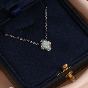 Detail eines ovalen Opal-Anhängers mit Kristallrand in einer blauen Samt-Box