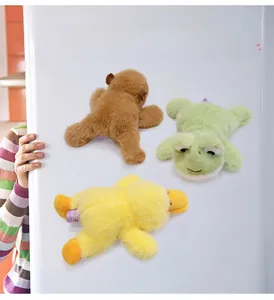 Detail of plush animal fridge magnets in bear, frog and duck shapes on a fridge