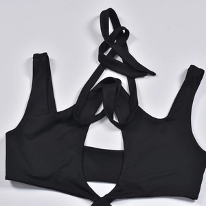 Dettaglio dell'abito nero con taglio cut-out, lacci a girocollo e tessuto elasticizzato