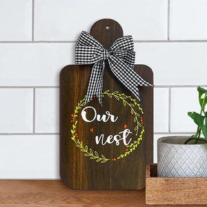 Creative wooden cutting board ornament with Our Nest design and plaid ribbon bow