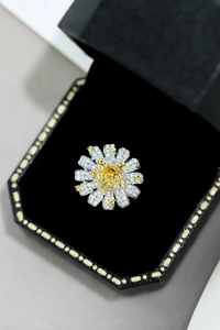Close-up of S925 silver daisy ring with yellow gemstone and zircons in a velvet box