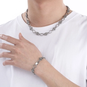 Détail du collier et bracelet élégants en acier inoxydable sur un mannequin masculin