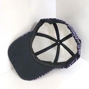 Detail view of purple leopard print baseball cap with white lining and metallic top button