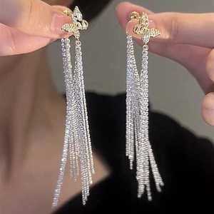 Vue détaillée des boucles d'oreilles argentées à pampilles avec papillons en cristal