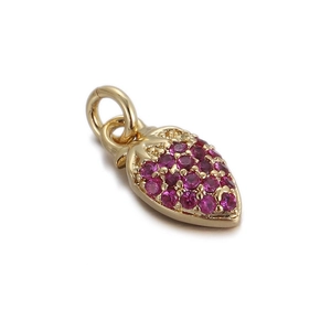 Macro view of 14k gold-plated strawberry pendant with ruby red crystal inlay and open ring