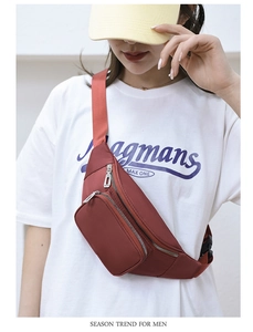 Detail showing the multi-layer zipper pockets and waterproof nylon fabric of the red-brown waist bag