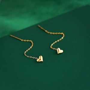 Elegant gold heart drop earrings on long threader chains with a polished metallic finish