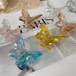 Detailed view of five colorful iridescent resin butterfly hair claws with gold springs