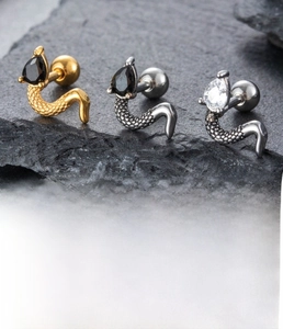 Detailed view of punk snake stud earring with zircon on black stone background