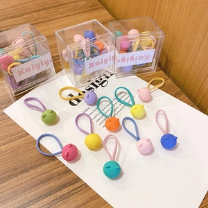 Close-up of colorful macaron flower hair ties for girls with high elastic bands in boxes