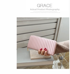 Detailed view of women's long pink quilted leather wallet with gold zipper and stylish tassel