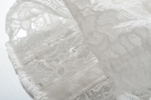 Macro detail of intricate white lace embroidery and floral texture for women's set