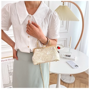 Detail of elegant floral embroidery on a vintage style cream white evening handbag