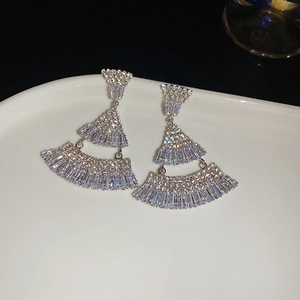 Detailed close-up of silver-tone three-tier fan-shaped earrings with clear zircon stones