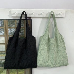 Close-up of embossed rose floral jacquard fabric on stylish canvas shoulder bags