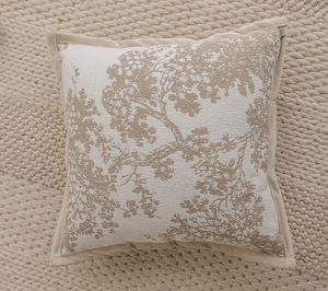 Detail of beige jacquard pillow cover featuring an intricate woven tree pattern