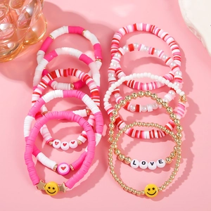 Detail view of colorful LOVE beaded bracelets with pink, red hearts and boho clay beads
