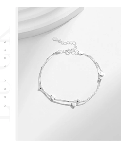 Macro shot of double-layer S925 sterling silver bracelet featuring glossy heart charms