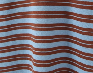 Close-up of orange and light blue striped knit fabric texture with fine vertical ribbing