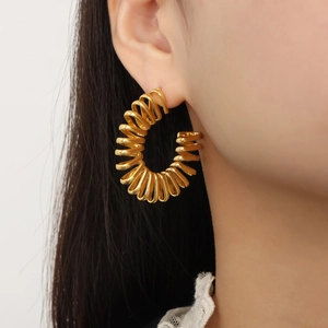 Boucles d'oreilles dorées irrégulières géométriques en C avec design en spirale sur l'oreille