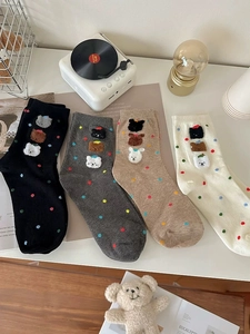 Dettaglio di quattro paia di calze di cotone con pois colorati e toppe di animali